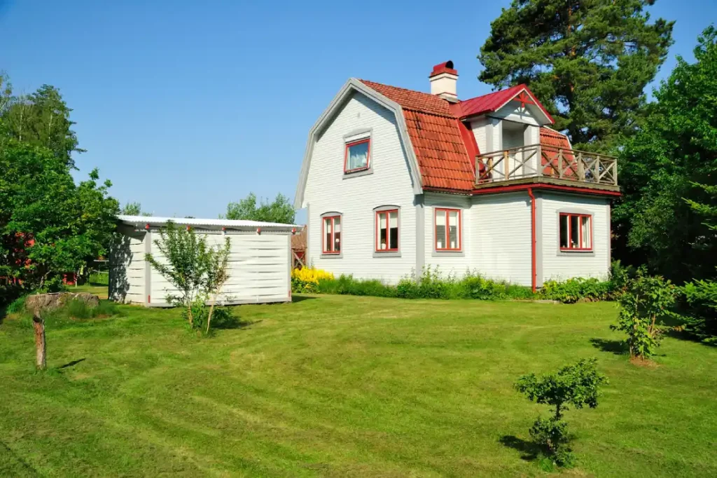 Periodieke controle vakantiehuis Zweden een huis met een tuin en een schuur.